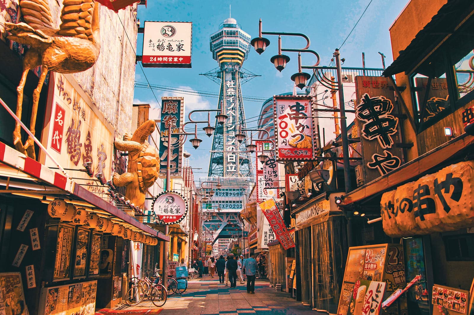 Horizonte urbano de Osaka con líneas de ferrocarril elevadas, calles densas y letreros de neón al anochecer